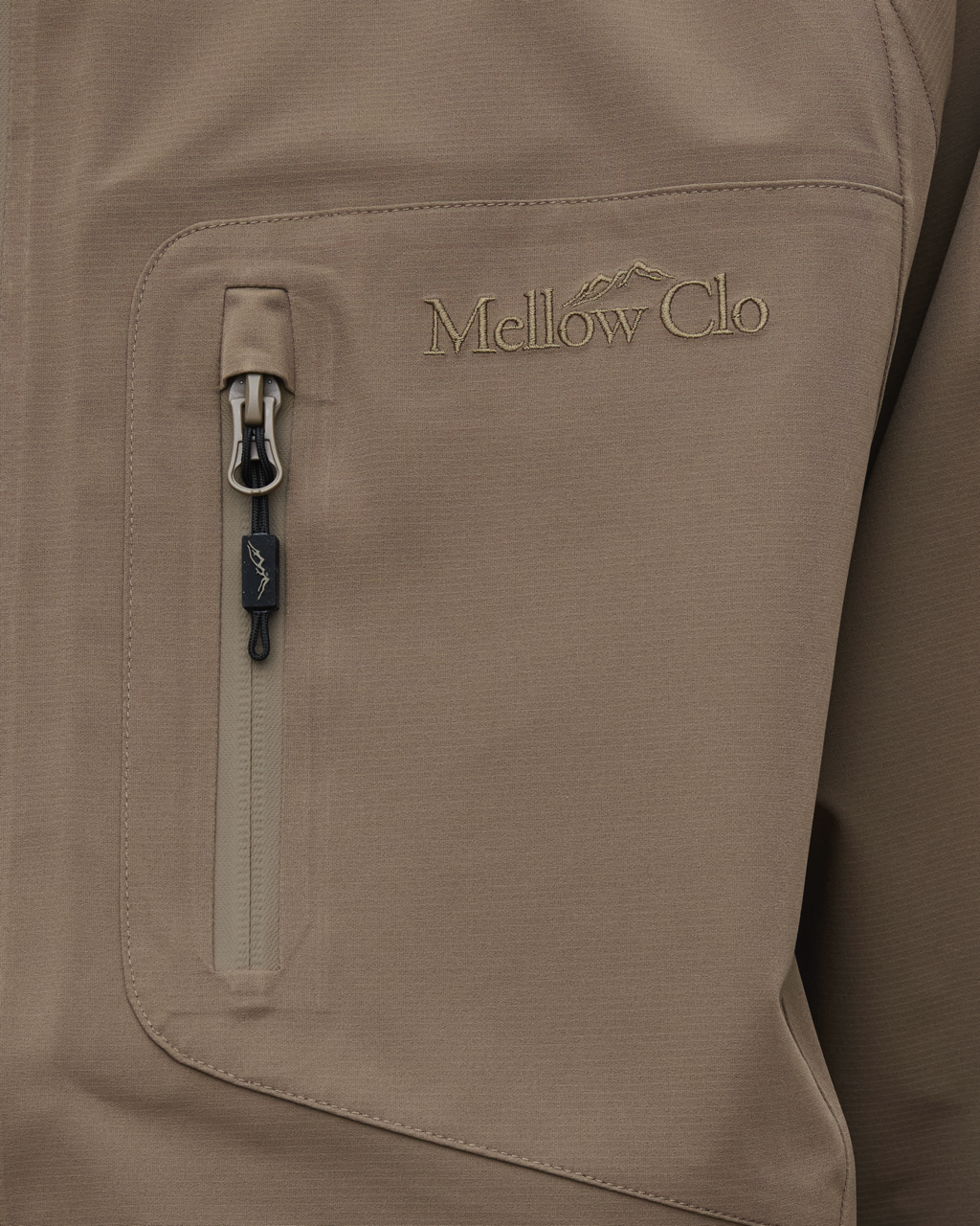 Close-up of a brown jacket with a zipper pocket and 'Mellow Clo' logo.
